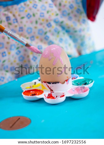 hand coloring easter eggs with colors and brush