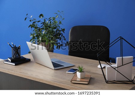 Modern laptop on workplace in room