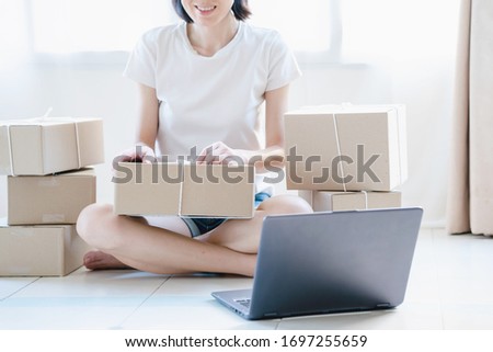 start up small business owner packing cardboard box at workplace. woman entrepreneur seller prepare parcel box of product for deliver to customer.