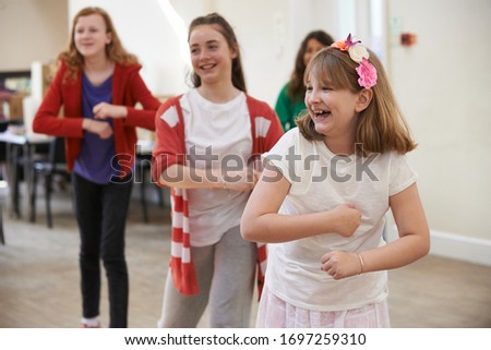 Group Of Children Enjoying Dance Lesson At Stage School Together Royalty-Free Stock Photo #1697259310