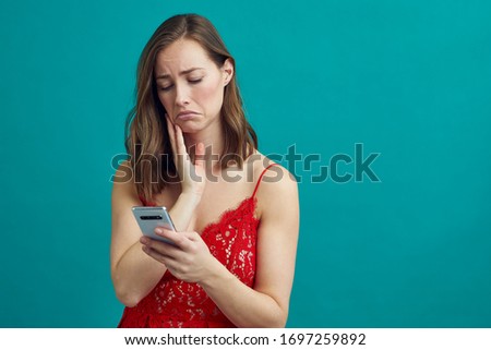 Beautiful woman standing with her phone and being sad for being stod up by her date
