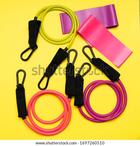 Expanders and elastic bands for fitness with different degrees of load on a yellow background. Sports equipment for activities	