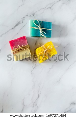 Top view of three ecologic handmade soap bars. White marble background. Copyspace