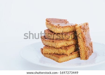 Stack of delicious freshly baked blondie brownie dessert slices on white background, close up. Copy space. Healthy vegan sugar free sweet bars. Vegetarian confection. Homemade pastry.