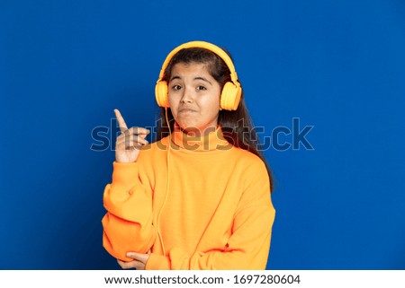 Adorable preteen girl with yellow jersey on a blue background