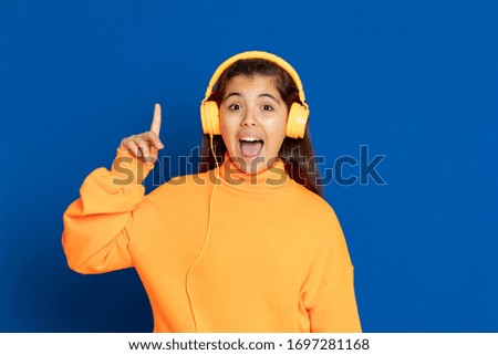 Adorable preteen girl with yellow jersey on a blue background