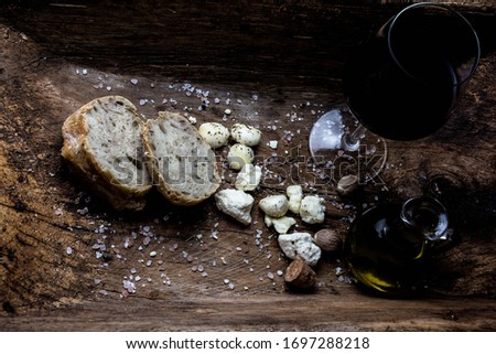 Wine, homemade brad and cheese on dark  wooden background. 