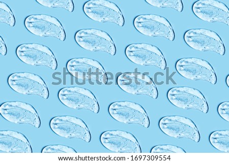 Group of transparent gel smears on blue background. Virus protection or cosmetics concept. Loopable elements. Royalty-Free Stock Photo #1697309554