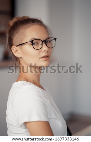 Portrait of a cute blonde wearing glasses at home