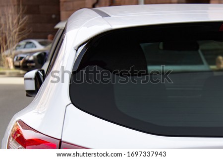 Back window of a white car parked on the street, rear view. Mock-up for sticker or decals Royalty-Free Stock Photo #1697337943