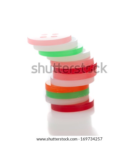 Close-up of a pile of plastic round tokens, symbol of currencies, gaming and diversity, on white background