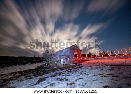 long exposure photo of a house illuminated with red light on a mountain in winter