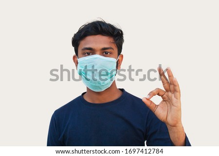 Young boy Wearing Protective Mask and Showing OK sign

