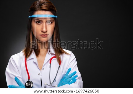 Young woman doctor posing with visor mask. Royalty-Free Stock Photo #1697426050