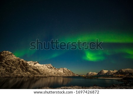 polar lights, aurora borealis, northern lights with many stars in the sky over mountains in the North of Europe , Lofoten islands, Norway, long shutter speed.