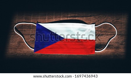 Czech Republic National Flag at medical, surgical, protection mask on black wooden background. Coronavirus Covid–19, Prevent infection, illness or flu. State of Emergency, Lockdown