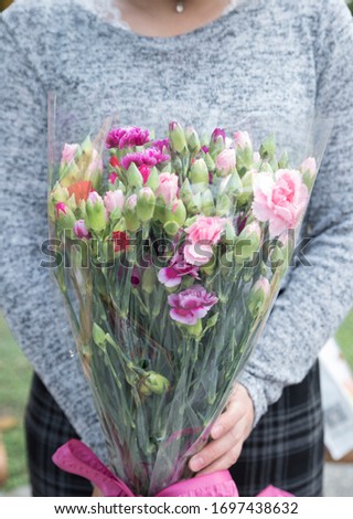 Girl holding carnations in hand