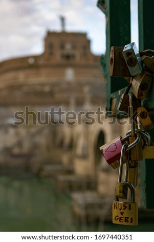 padlock and behind the view of castel san'angelo in rome.