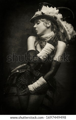 Old-fashioned black and white portrait of a young cabaret showgirl in her stage costume Royalty-Free Stock Photo #1697449498