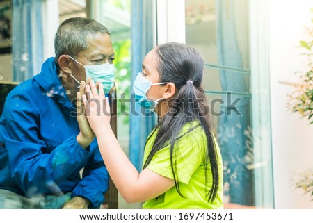 Social distancing among the family, Father and daughter on a window plane, concept coronavirus and covid-19 pandemic.Outbreak Across the World.soft focus. Royalty-Free Stock Photo #1697453671