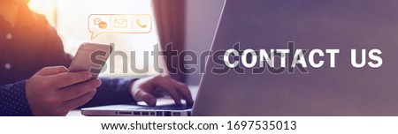 Close up businessman using laptop holding mobile smart phone, using device to contact people or contacting information on business, concept of contact us messaging calling email, with graphic icon  Royalty-Free Stock Photo #1697535013