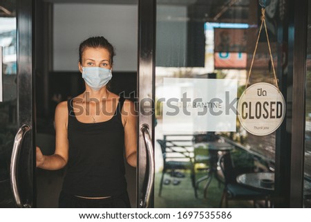 Store Owner in medical mask closed restaurant for quarantine