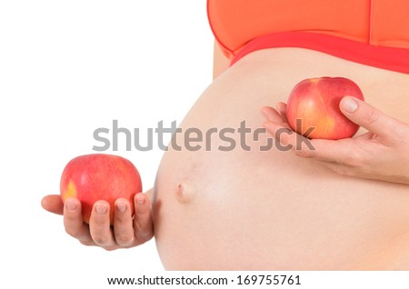 belly of pregnant woman who holds apples: health nutrition