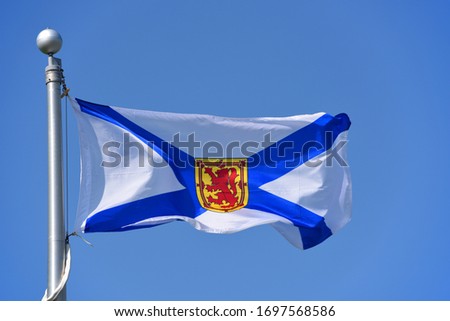 Flag of Nova Scotia province on blue sky. Photo taken in Grand Pre in Nova Scotia, Canada.