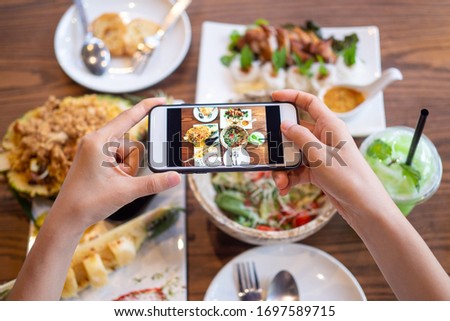 woman using a mobile camera take pictures of food placed on the table in house. After calling to order food online from home. Stay at home and shopping online during the spread of the covid-19 virus.