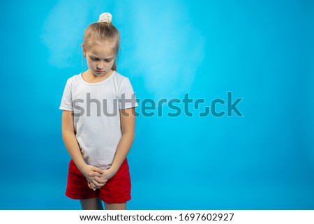 a schoolgirl stands on a blue background 