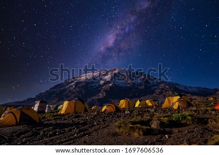 Beautiful view of the milky way over mount Kilimanjaro, Tanzania with many tents at the base camp. Millions of stars in the night African sky. Royalty-Free Stock Photo #1697606536