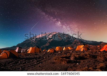 Beautiful view of the milky way over mount Kilimanjaro, Tanzania with many tents at the base camp. Millions of stars in the night African sky. Royalty-Free Stock Photo #1697606545