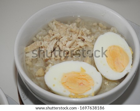 Delicious chicken porridge with boiled eggs in a cup Royalty-Free Stock Photo #1697638186