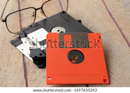 A close up of an old diskette stacked on a wooden table selective focus and shallow depth of field