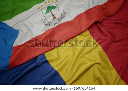 waving colorful flag of romania and national flag of equatorial guinea. macro