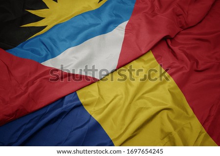 waving colorful flag of romania and national flag of antigua and barbuda. macro