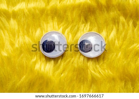 Funny Wiggle Google Eyes on Fabric Silly Yellow Furry Background
