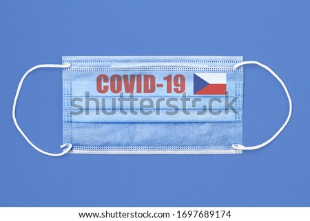 Medical mask and text or inscription Covid-19. Coronavirus pandemic concept. Flag of the Czech Republic.