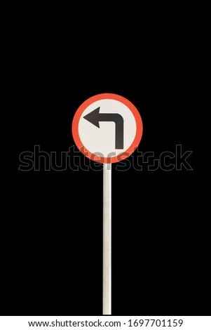 Left arrow with red edge circular badge with old rusted iron pole. Traffic sign signage. isolated with black background.