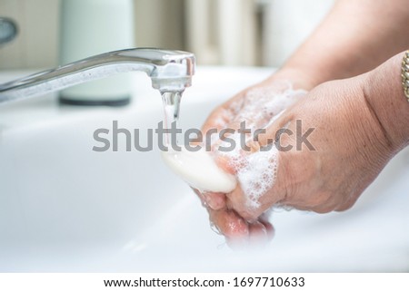 Washing hands with soap under the faucet with water. Coronavirus pandemic prevention.