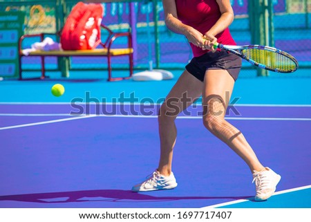 girls play tennis on a hard blue court Royalty-Free Stock Photo #1697717407