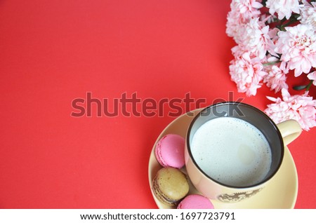 beige cup cappuccino beautiful white-pink aster flowers on a red background. good morning. greeting card. view from above. save space cookies macarune Mothers day or Womens day