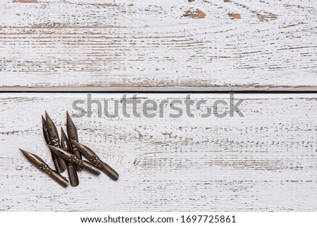 sharp pen for calligraphy. light wood background. retro style