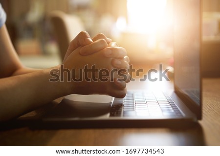 Hand praying with laptop, Church online Sunday services concept, Home church during quarantine coronavirus Covid-19, Hands folded in prayer concept for faith. Royalty-Free Stock Photo #1697734543