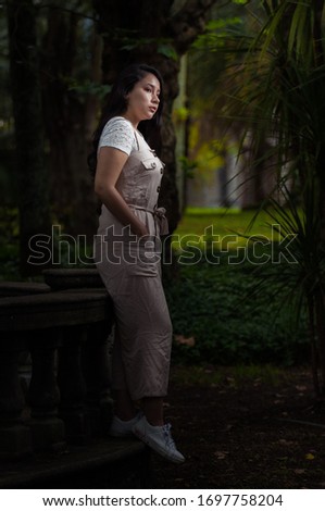 young woman standing in the middle of the forest dark tone