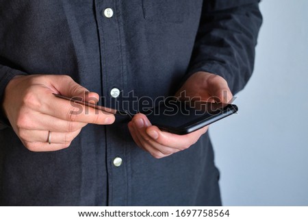 A man holds a smartphone and a credit card in his hands. Payment by card online using phone. Ordering or booking through the online store. Businessman with a device. Modern technology in life