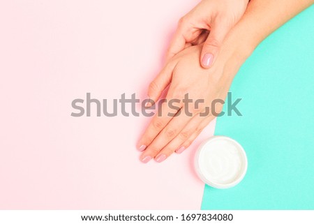female  manicure. Beautiful young woman's hands with cream  on pastel background - Image 