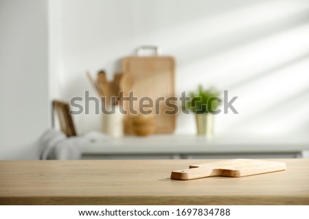 Table background of free space and kitchen interior.White wall with shadows and sunny warm morning time.Copy space for your composition. 