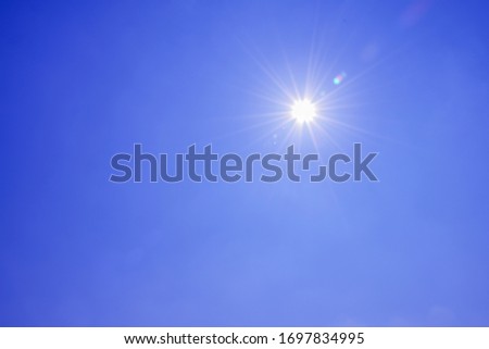 Blur image of a Beautiful morning Sun shines in blue sky.sunburst with Lens flare light over black background. 