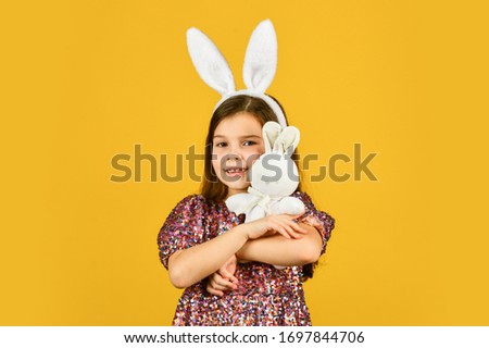 Springtime. small girl hold hare toy. happy childhood. cute child play with toy. toy shop concept. girl in funny rabbit ears. happy easter holiday. spring holiday preparation. easter bunny kid.